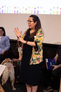 Mujer de pie haciendo seña con las manos