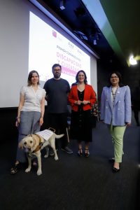 Cuatro personas de pie mirando a la cámara y una de ellas está con su perro guía